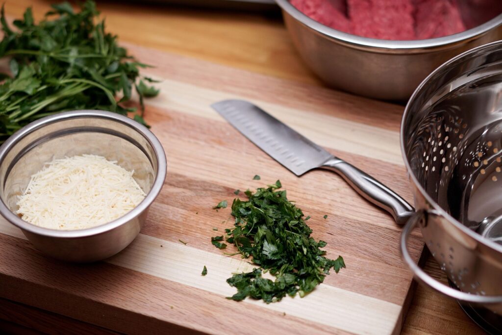 kitchen, cooking, knife, cilantro, mixing bowl, strainer bowl, strainer, kitchenware, parmesan, shredded cheese, shredded parmesan, cutting board, wood cutting board, kitchen, kitchen, kitchen, kitchen, cooking, cooking, cooking, cooking, cooking, knife, cutting board